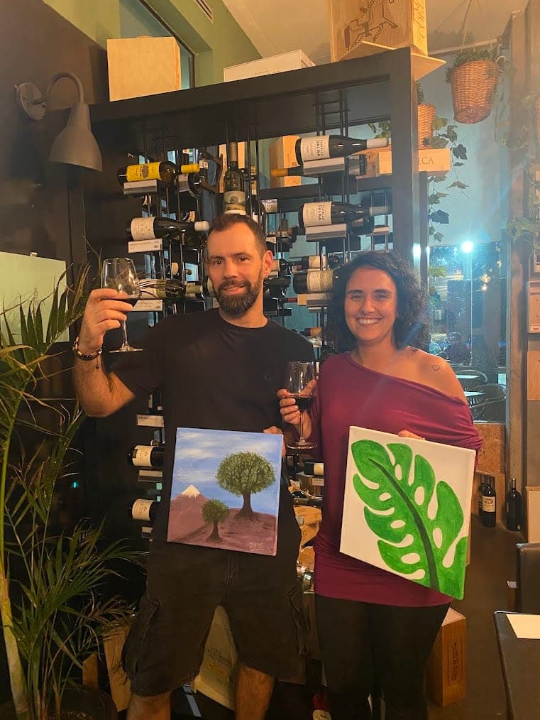 A couple toasting with their paintings