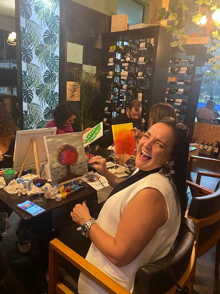 Carina laughing while painting a tree