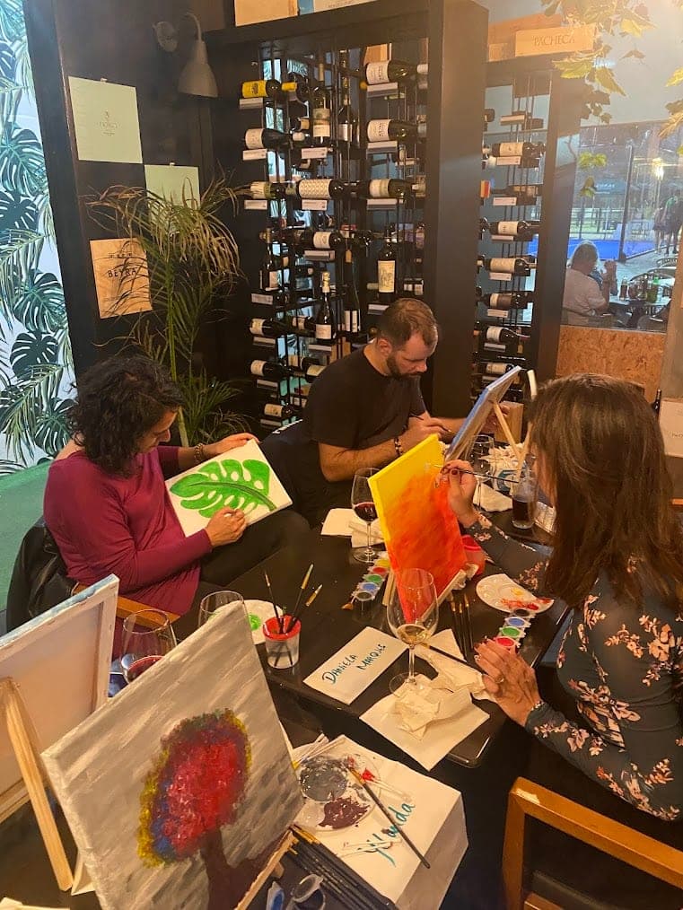 Guests painting a monstera leaf and a sunset