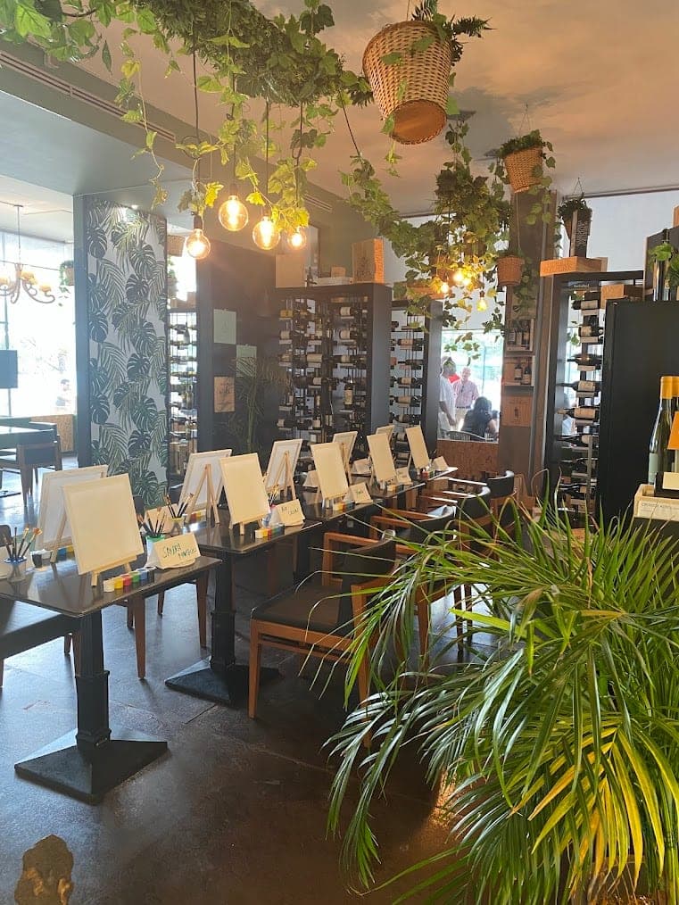 Easels set up among the plants and wine racks